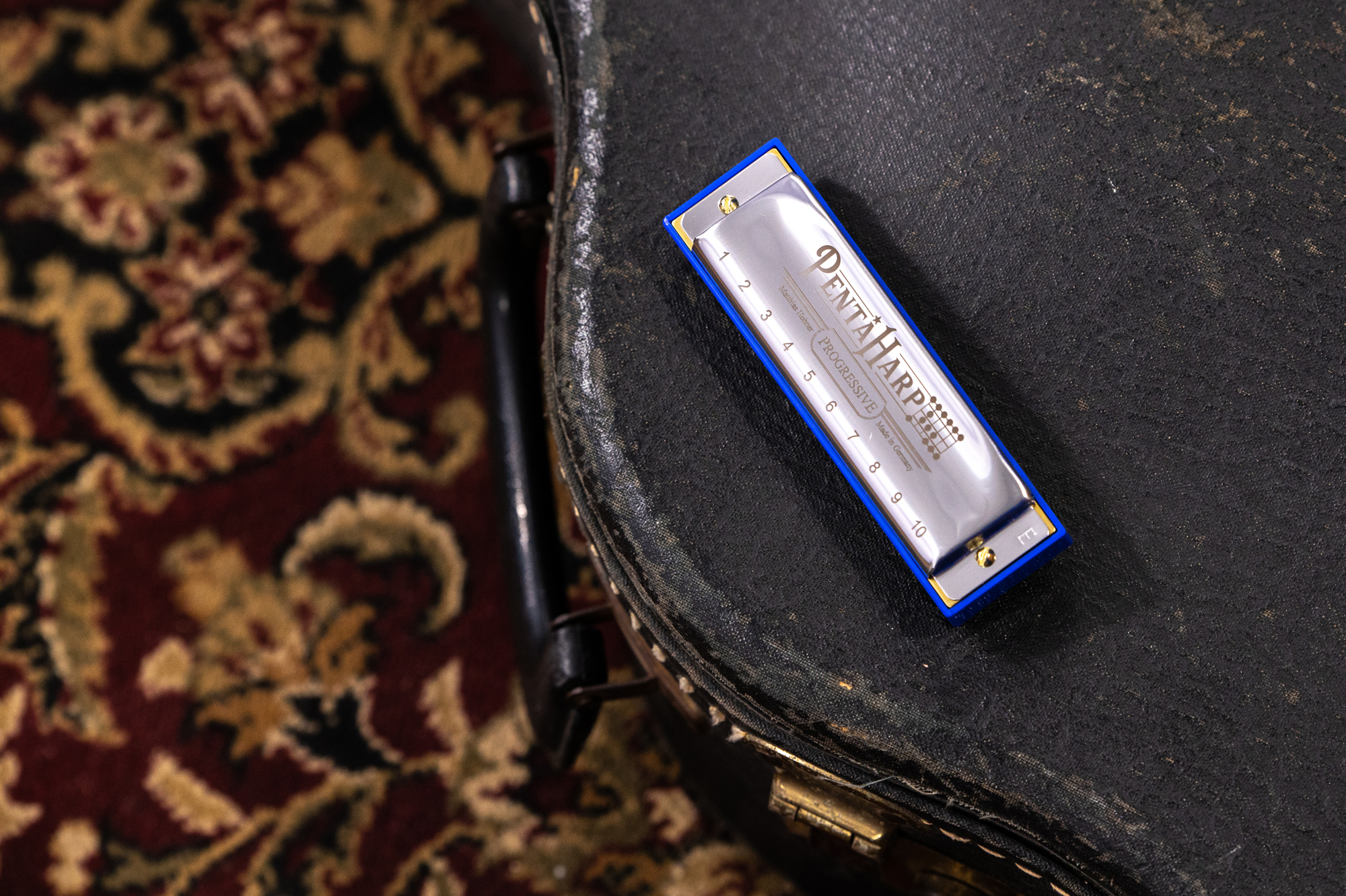 Die Penta Harp von Hohner liegt auf einem Gitarrenkoffer.