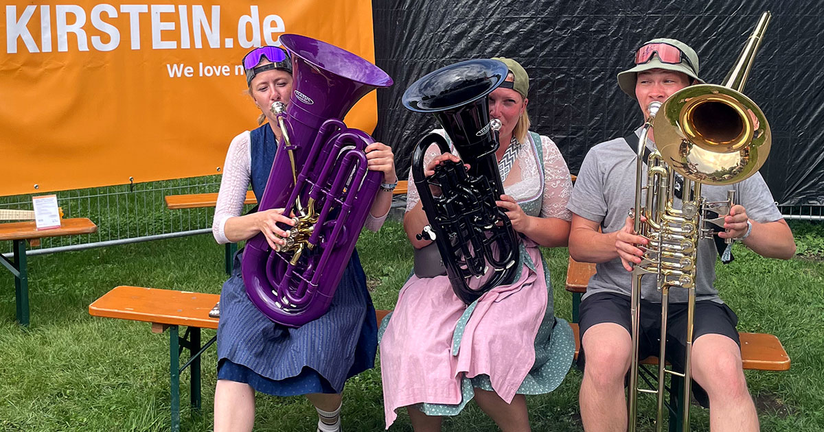Besucher der Brass Wiesn 2024 spielen auf MardiBrass Kunststoffinstrumenten